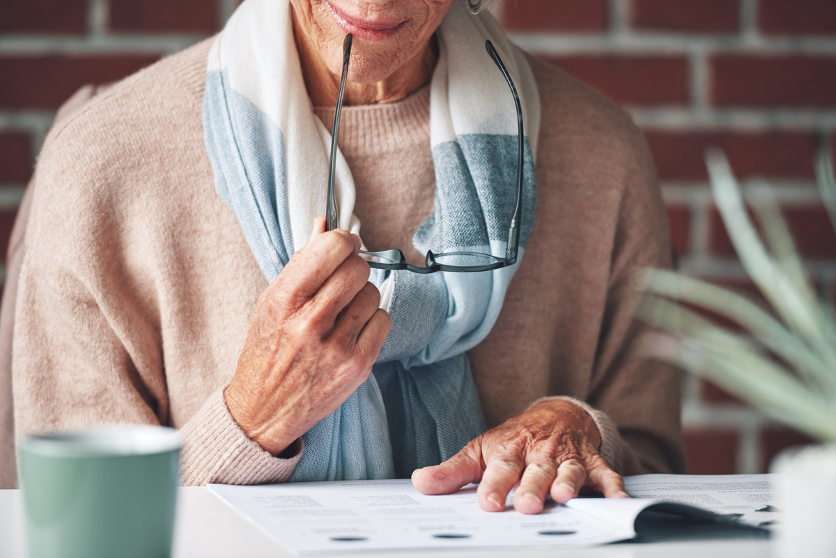 Mature woman, reading and document in the indoor with closeup an